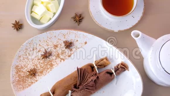 巧克力俄式薄饼布里尼和凝乳馅在盘子里提供了一杯茶和黄油上景视频的预览图