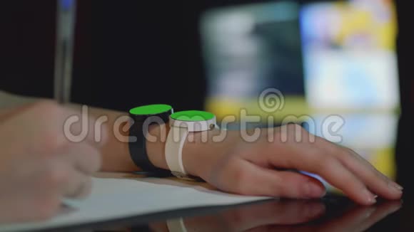 年轻的白人女孩总是一只手按着绿色屏幕上的两只手表关闭视频的预览图