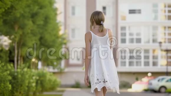 漂亮的年轻漂亮的金发女郎穿着白色蕾丝连衣裙散步给你迷人的外观视频的预览图