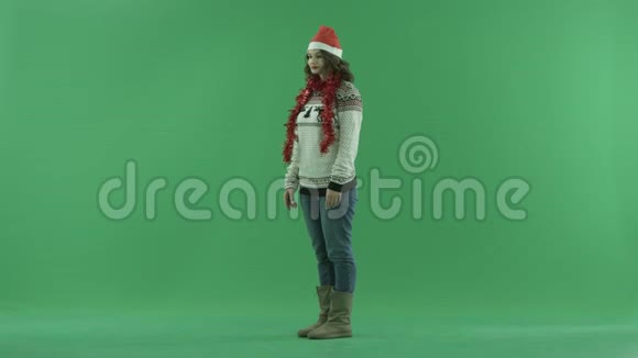 使用增强现实屏幕技术制作圣诞帽的迷人年轻女性背景色键视频的预览图