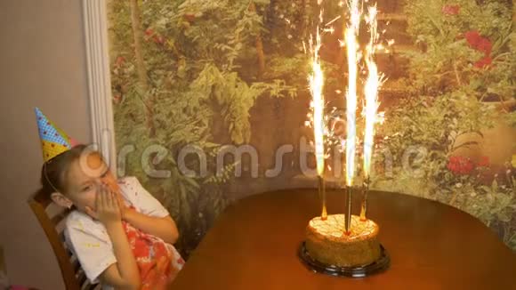 在蛋糕里喷火喷泉蛋糕在女孩面前的桌子上女孩子生日带灯的蛋糕女孩是视频的预览图