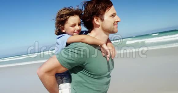 父亲在海滩上背着儿子视频的预览图