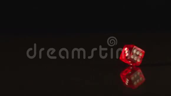 红色塑料骰子旋转黑色背景视频的预览图