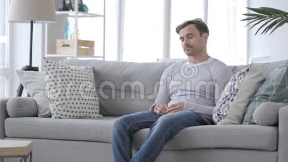 疲惫的成年人坐在沙发上睡觉视频的预览图