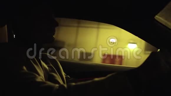 年轻商人在地下隧道驾驶汽车的剪影视频的预览图