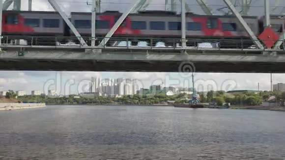 从空中俯瞰铁路大桥上面有一列移动的火车穿过流经一个主要城市的河流视频的预览图