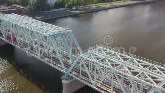 从空中俯瞰铁路大桥上面有一列移动的火车穿过流经一个主要城市的河流视频的预览图