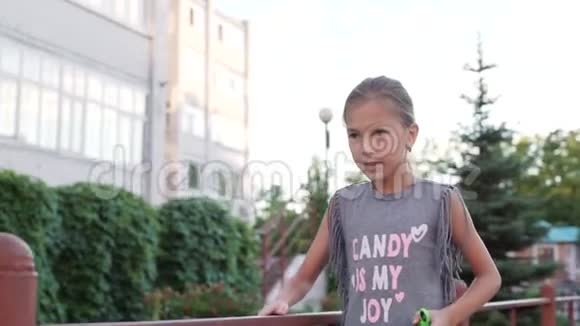 一个手里拿着旋转器的小女孩正走在房子的院子里视频的预览图