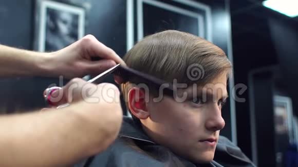 男人理发师剪了一个悲伤男孩的头发视频的预览图