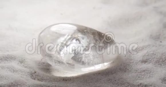 莱茵石或岩石水晶宝石在沙子上旋转视频的预览图