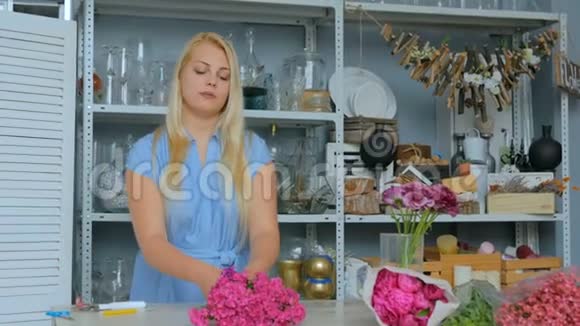 专业花艺师在工作坊为花束准备粉色土耳其康乃馨视频的预览图