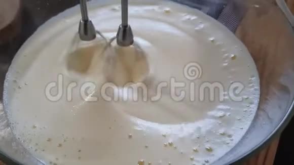 搅拌机迅速转动一个盘子上面有鸡蛋和牛奶的液体面糊奶油或煎饼视频的预览图