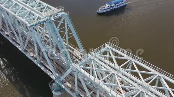 从空中俯瞰铁路大桥上面有一列移动的火车穿过流经一个主要城市的河流视频的预览图