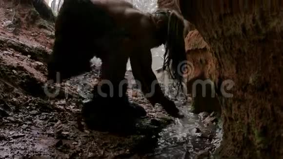 史前穴居人在冬林背景下的洞穴里洗澡视频的预览图