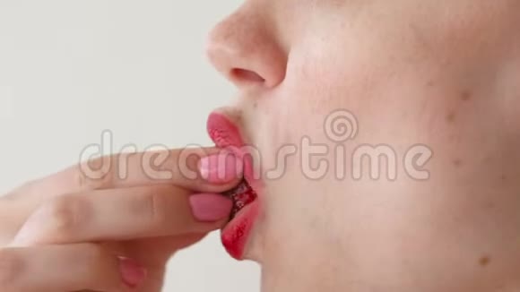 嘴唇红的女人吃草莓口特写侧视视频的预览图
