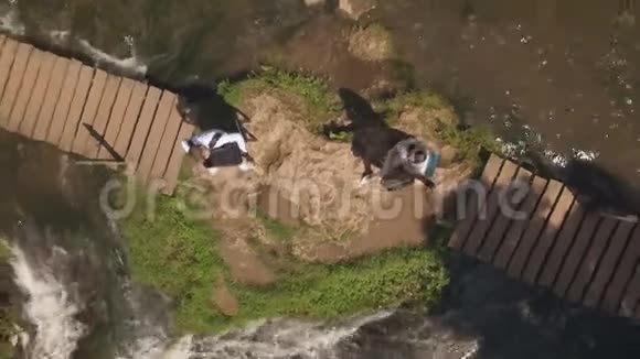 空中观景两位音乐家Pianist和bandura在瀑布的岩石上演奏视频的预览图