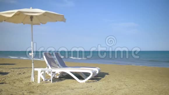 海边的沙滩上有太阳伞和太阳伞视频的预览图