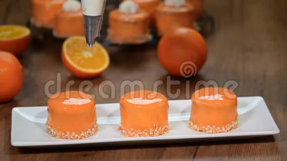 用橙色鲜奶油装饰小蛋糕视频的预览图