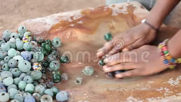 加纳制造过程中玻璃珠的手工清洗视频的预览图