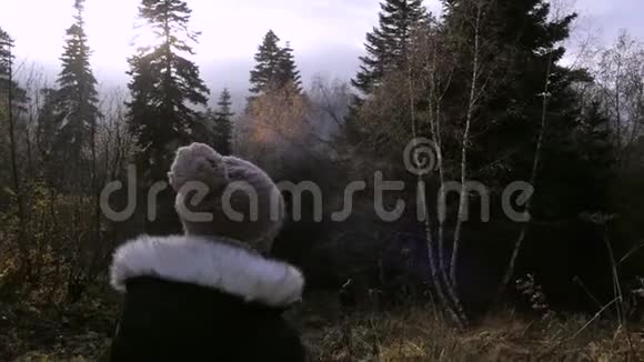 女孩走在秋天的森林里在山上慢悠悠视频的预览图