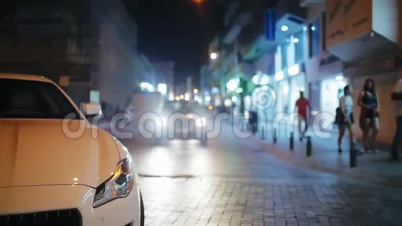 穿过马路移动的汽车和人们在晚上穿过马路视频的预览图