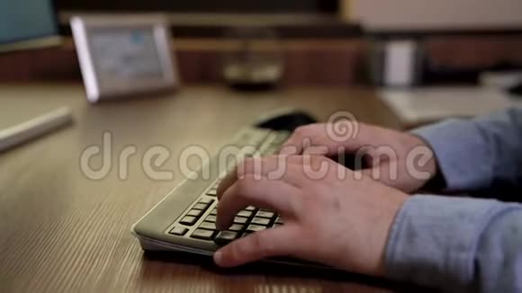 商人手在键盘上打字蓝色衬衫木制桌子机动滑块录像视频的预览图