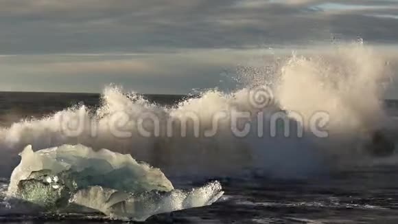 冰山和蓝白冰块在波浪上滚动波浪在冰上破碎日出时在海滩冲浪伊塞拉视频的预览图