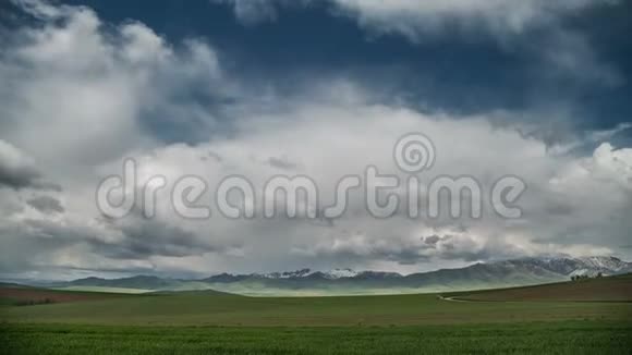 在云的地平线上绿色的草地和山脉延时4K视频的预览图