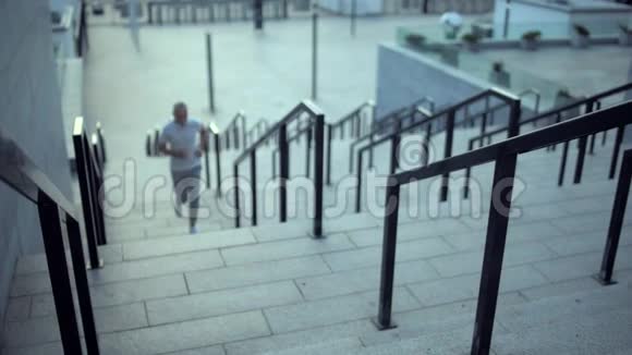 一位运动健将跑上楼梯后休息视频的预览图