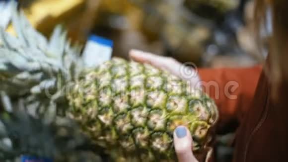 在商店或市场上挑选大菠萝的女士的手特写视频的预览图