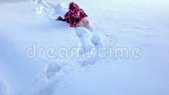 一个快乐的孩子在粉红色的整体玩雪视频的预览图