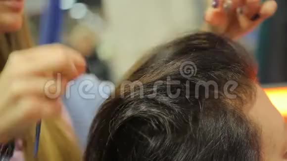 有经验的发型师为女性顾客创造美丽的发型视频的预览图