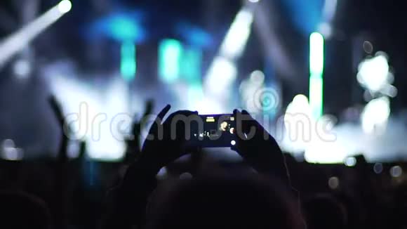 人们的手在舞台上为流行歌星拍照观众鼓掌视频的预览图