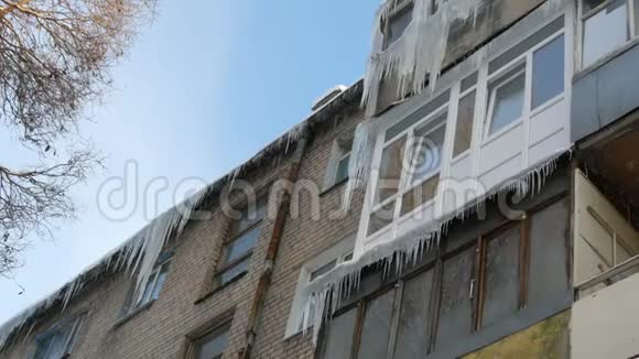 旧废弃的房子和它的阳台在冬天有大量融化的冰柱视频的预览图
