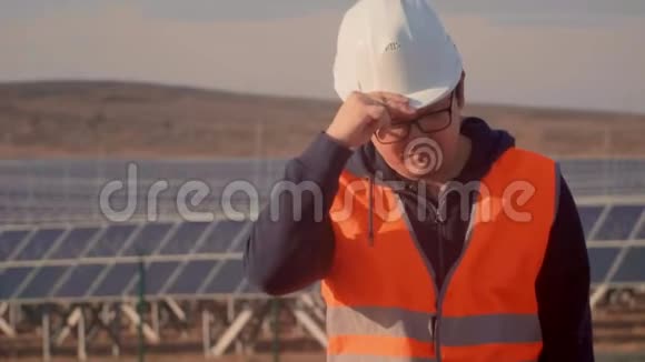一个穿着工程师服的亚洲人在太阳能发电厂的背景下看着地平线视频的预览图