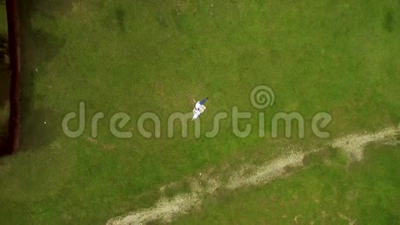 两个情人躺在他们旁边的绿草上摄像机慢慢地从他们身边飞走了四架直升机射击视频的预览图