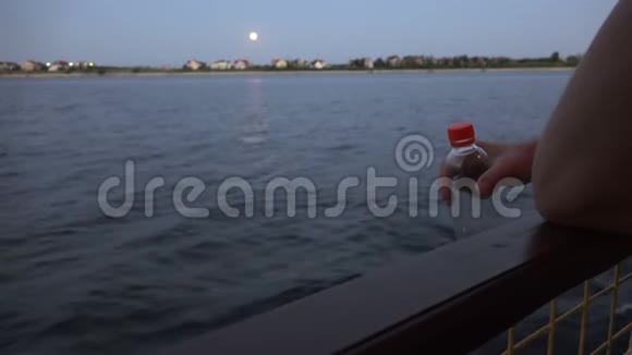 一个水手拿着一个塑料瓶上面有一个红色的盖子视频的预览图