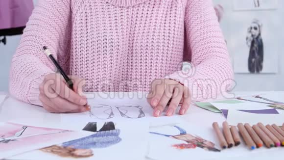 设计师的着装手用铅笔为服装杂志创作漂亮的图纸关门视频的预览图