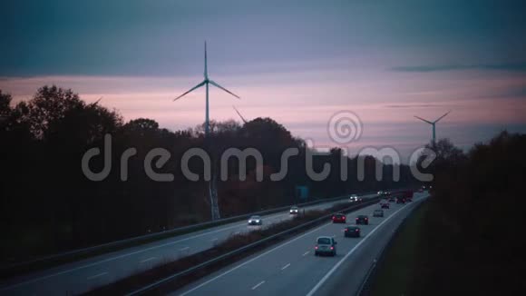 日落天空背景下的电动汽车和风车时间流逝视频的预览图