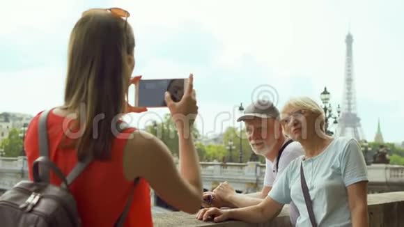 女儿在巴黎度假旅行中给资深父母拍照靠近埃菲尔铁塔和塞纳河视频的预览图