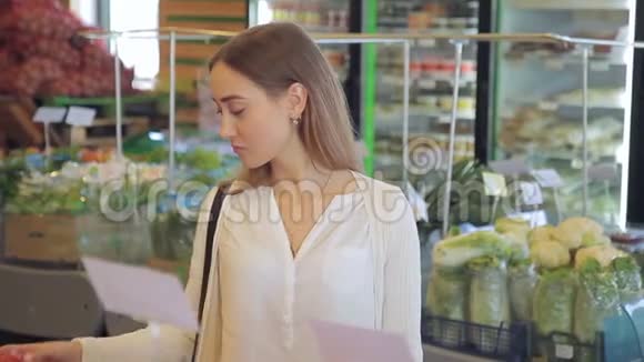漂亮的女人在超市里独自选择西红柿视频的预览图