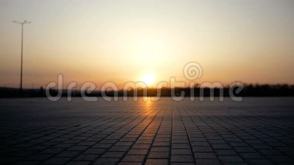 两个人骑着自行车在一个大面积的地方走向日落在太阳的背景下剪影视频的预览图
