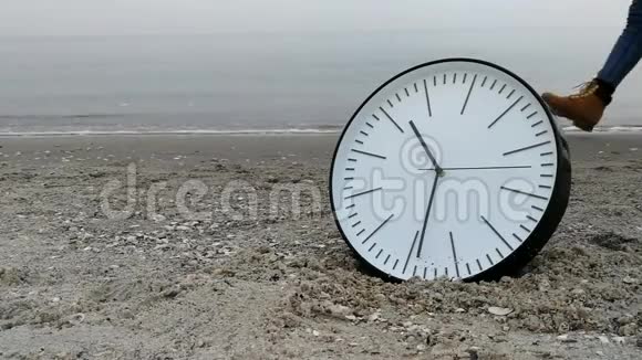 时间概念沙滩上的时钟背景步行夫妇腿海平线视频的预览图