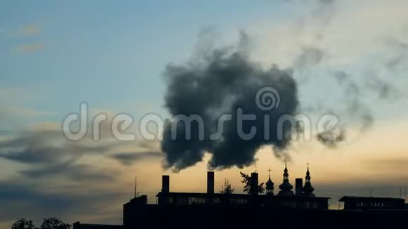时间推移视频以查看来自几个工厂管道的烟雾在教堂的背景上视频的预览图