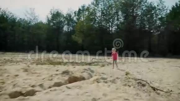 小女孩跑过森林里的沙滩视频的预览图