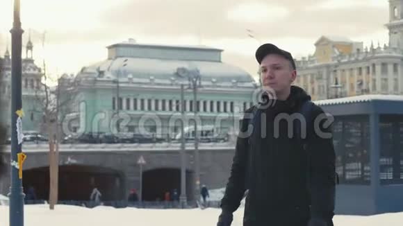 冬天男人在现代城市的街头散步视频的预览图