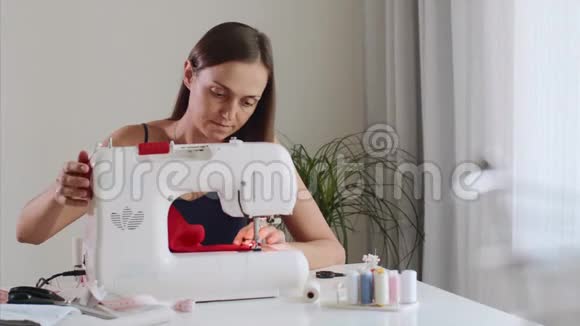 自营女裁缝在缝纫机上工作和缝纫布视频的预览图