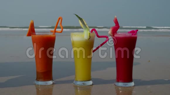 三杯刚榨出的果汁放在印度洋的岸边4k视频的预览图