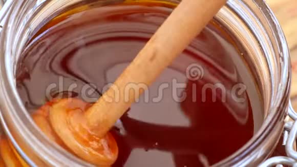 木制蜜盘在罐子里搅拌蜂蜜视频的预览图
