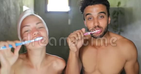 一对在卫生间刷牙的夫妇谈情说爱快乐的男人和女人微笑着做晨间卫生视频的预览图